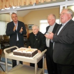 Canon Neville cutting the cake